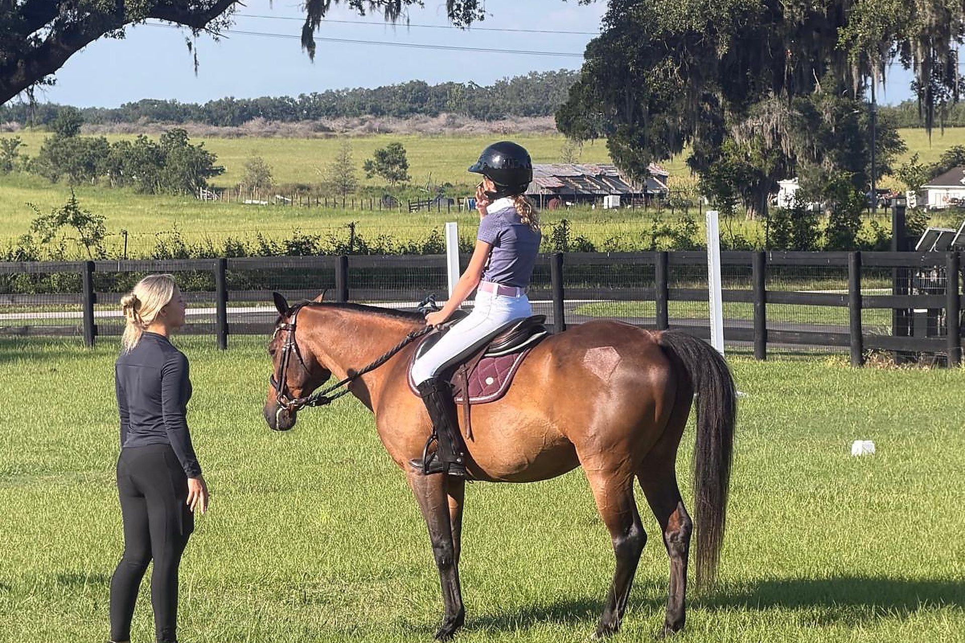 Leigh Kostmayer teaching a young rider in the field at Ashby Equestrian in Anthony, Florida